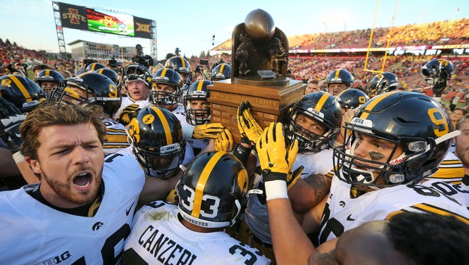 Iowa celebrates with the Cy-Hawk Trophy Saturday, Sept. 12 2015, at Jack Trice Stadium in Ames after defeating Iowa State, 31-17.
