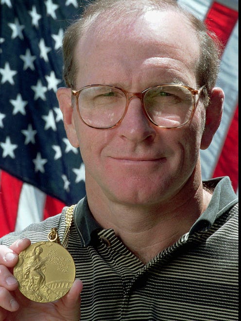 Dan Gable displays his wrestling gold medal in Iowa City, Iowa in 1996.