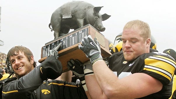 Iowa football players Jayme Murphy, left, Chad Geary carry the Floyd of Rosedale trophy off the field following Iowa's 12-0 victory over Minnesota on Saturday, Nov. 21, 2009, at Kinnick Stadium in Iowa City.