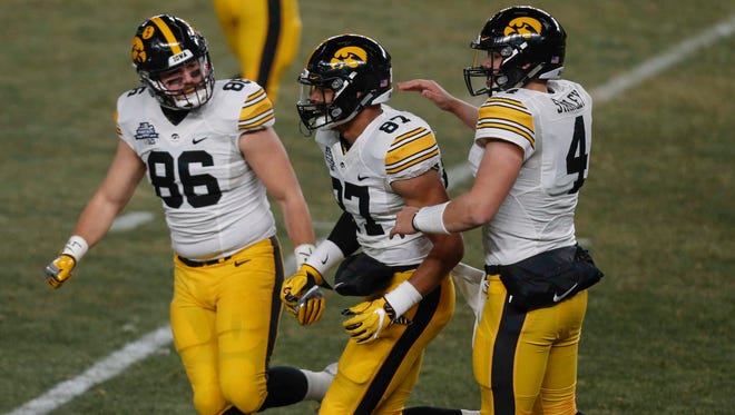 Iowa tight end Peter Pekar (86) and quarterback Nate Stanley (4) celebrate with tight end Noah Fant after Fant pulled in a touchdown in the second quarter against Boston College during the 2017 Pinstripe Bowl at Yankee Stadium in Bronx, New York on Wednesday, Dec. 27, 2017.