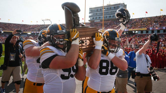 From 2017: Members of the Iowa Hawkeyes football team triumphantly carry the Cy-Hawk trophy off the field after their 44-41 win over Iowa State on Sept. 9, 2017, at Jack Trice Stadium in Ames.