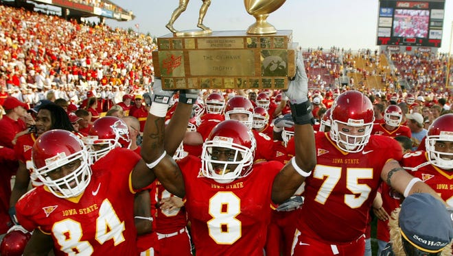 Iowa State University's Jason Berryman (84), Steve Paris (8) and Aaron Brant (75) march the Cy-Hawk trophy back to the locker room after the Cyclones beat the Iowa Hawkeyes, 23-3, Sept. 10, 2005 at Jack Trice Stadium in Ames.