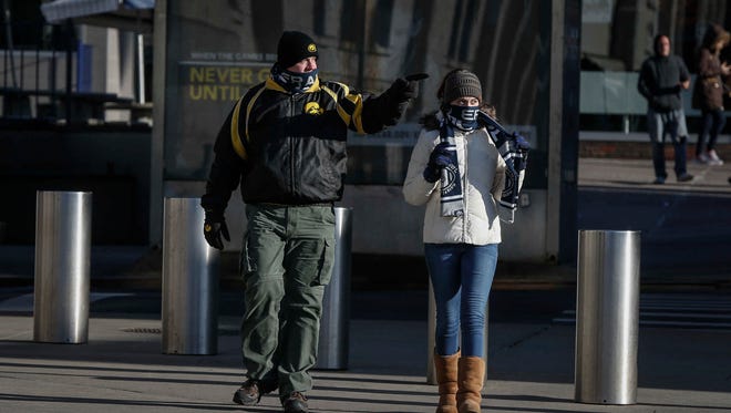 Doug Peters and his daughter, Abby, 15, of Burlington, bundle up as they make their way toward Yankee Stadium for the 2017 Pinstripe Bowl between Iowa and Boston College in Bronx, New York, on Wednesday, Dec. 27, 2017.