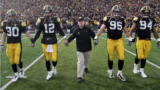 Honorary captain Dan Gable takes the field with Iowa team captains Brett Greenwood, Ricky Stanzi, Karl Klug and Adrian Clayborn, for the coin toss, before the Ohio State game, Saturday, Nov. 20, 2010, at Kinnick Stadium, in Iowa City.
