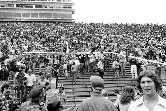Hawkeyes fans tore down the goalpost and carried it into the Kinnick Stadium stands after Iowa beat Iowa State, 12-10, in 1977 as the Cy-Hawk rivalry resumed.