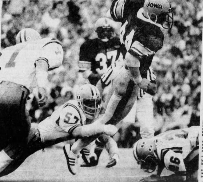 Iowa's Jon Lazar (44) lunges out of the grasp of Iowa State's Mark Settle (57) to score a touchdown in the 1977 Cy-Hawk football game.