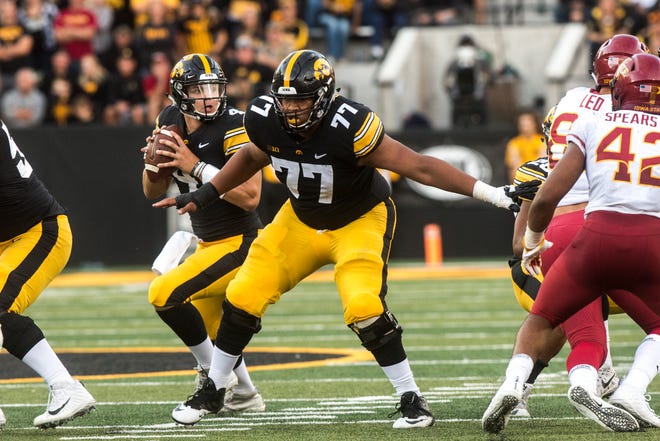 Iowa quarterback Nate Stanley (4) looks to pass while offensive lineman Alaric Jackson (77) protects the pocket during the Cy-Hawk NCAA football game on Saturday, Sept. 8, 2018, at Kinnick Stadium in Iowa City.