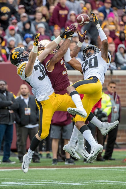 Oct 6, 2018; Minneapolis, MN, USA; Minnesota Golden Gophers wide receiver Chris Autman-Bell (3) and Iowa Hawkeyes defensive back Jake Gervase (30) and defensive back Julius Brents (20) battle for a pass in the first half at TCF Bank Stadium. Mandatory Credit: Jesse Johnson-USA TODAY Sports