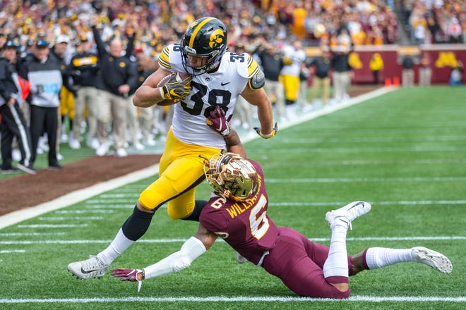 Oct 6, 2018; Minneapolis, MN, USA; Iowa Hawkeyes tight end T.J. Hockenson (38) rushes for a touchdown on a fake field goal attempt against Minnesota Golden Gophers defensive back Chris Williamson (6) in the first half at TCF Bank Stadium. Mandatory Credit: Jesse Johnson-USA TODAY Sports