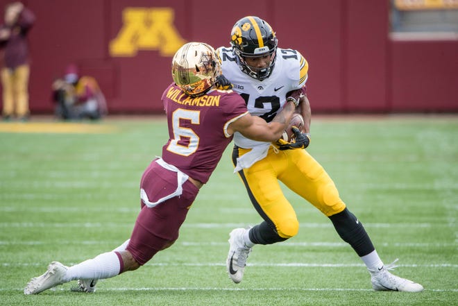 Oct 6, 2018; Minneapolis, MN, USA; Iowa Hawkeyes wide receiver Brandon Smith (12) pushes for a first down after catching a pass against Minnesota Golden Gophers defensive back Chris Williamson in the first quarter at TCF Bank Stadium.