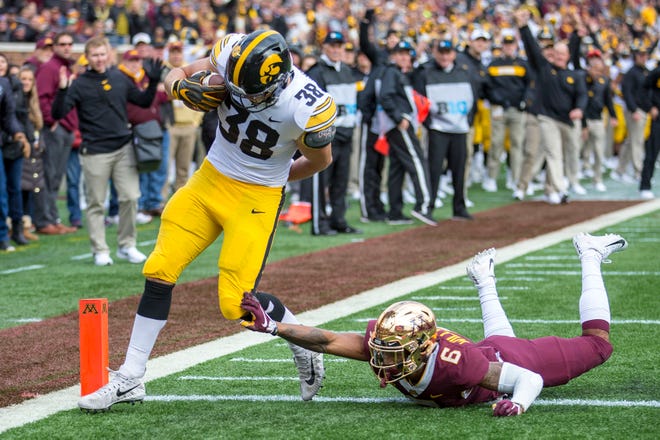 Oct 6, 2018; Minneapolis, MN, USA; Iowa Hawkeyes tight end T.J. Hockenson (38) rushes for a touchdown on a fake field goal attempt against Minnesota Golden Gophers defensive back Chris Williamson (6) in the first half at TCF Bank Stadium. Mandatory Credit: Jesse Johnson-USA TODAY Sports