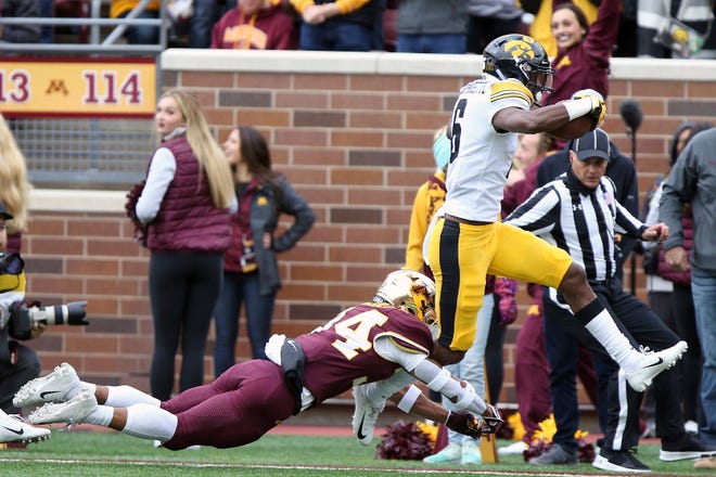 Iowa wide receiver Ihmir Smith-Marsette runs the ball into the end zone through the arms of Minnesota's defensive back Antonio Shenault during an NCAA college football game Saturday, Oct. 6, 2018, in Minneapolis. (AP Photo/Stacy Bengs)