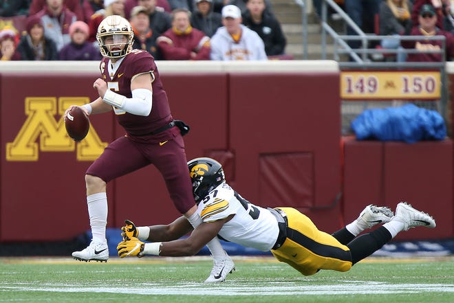 Minnesota quarterback Zack Annexstad tries to avoid a tackle by Iowa's Chauncey Golston during an NCAA college football game Saturday, Oct. 6, 2018, in Minneapolis. (AP Photo/Stacy Bengs)