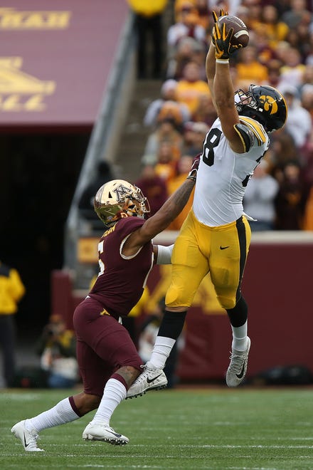 Iowa tight end T.J. Hockenson tries to catch the ball against Minnesota's defensive back Chris Williamson during an NCAA college football game Saturday, Oct. 6, 2018, in Minneapolis. Iowa won 48-31. (AP Photo/Stacy Bengs)