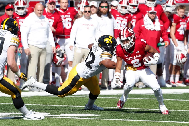 Indiana Hoosiers running back Reese Taylor (2) runs with the ball against Iowa Hawkeyes linebacker Djimon Colbert (32) during the first quarter at Memorial Stadium .