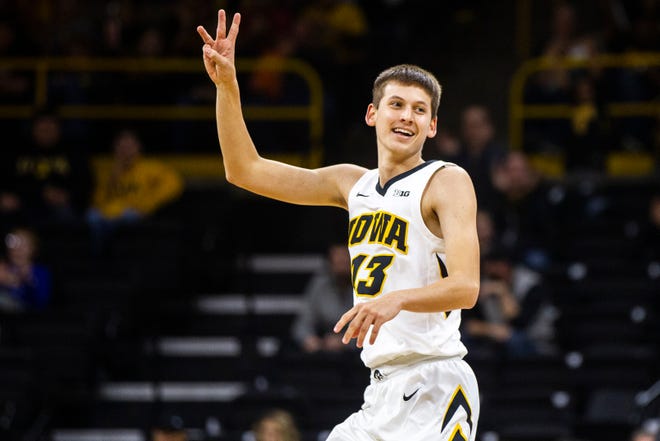 Iowa guard Austin Ash (13) holds up three fingers after making a 3-point basket during an NCAA men's basketball game on Wednesday, Nov. 21, 2018, at Carver-Hawkeye Arena in Iowa City.