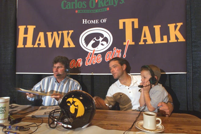 From 1999: Iowa football coach Kirk Ferentz holds his son, Steve, on his lap during the coach's weekly call-in show at Carlos O'Kelly's in Iowa City. At left is Iowa radio broadcaster Gary Dolphin.