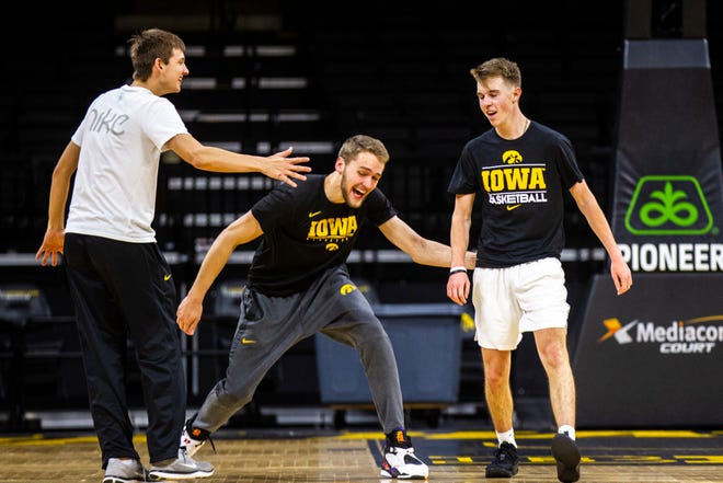 Iowa manager Jarrett Knepper is embraced by Iowa forward Riley Till (center) and Iowa guard Austin Ash (left) during a Cy-Hawk men's basketball managers game on Wednesday, Dec. 5, 2018, at Carver-Hawkeye Arena in Iowa City.