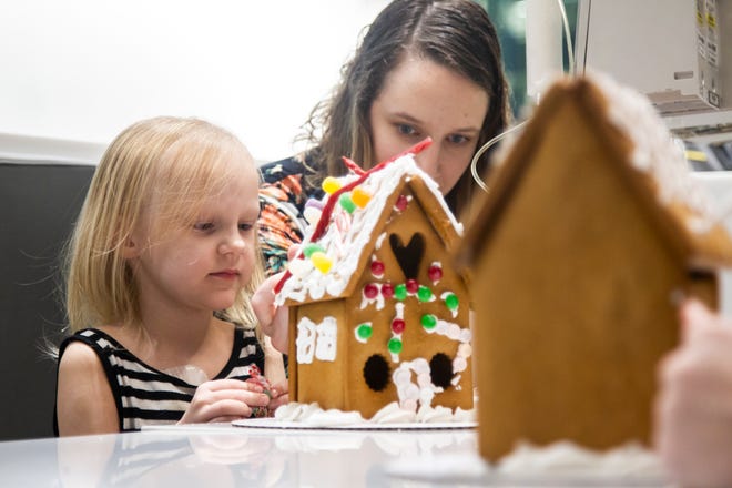 Shelby Kruse helps her daughter Ava while they decorate a gingerbread house together at an event on Tuesday, Dec. 18, 2018, at the Stead Family Children's Hospital in Iowa City.