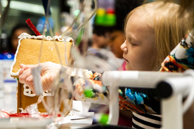 Shelby Kruse helps her daughter Ava while they decorate a gingerbread house together at an event on Tuesday, Dec. 18, 2018, at the Stead Family Children's Hospital in Iowa City.