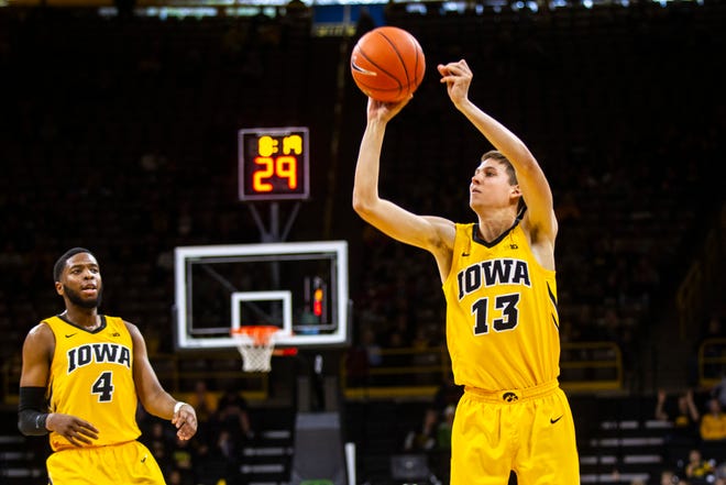 Iowa guard Austin Ash (13) shoots a 3-point basket as Iowa guard Isaiah Moss (4) looks on during a NCAA men's basketball game on Saturday, Dec. 22, 2018, at Carver-Hawkeye Arena in Iowa City.