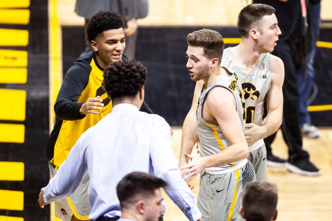 Iowa guard Jordan Bohannon (3) gets congratulations from teammates Iowa forward Cordell Pemsl (blue) and Nicolas Hobbs (left) heading into the locker room at the half during a NCAA Big Ten Conference men's basketball game on Sunday, Jan. 6, 2019, at the Carver-Hawkeye Arena in Iowa City, Iowa.