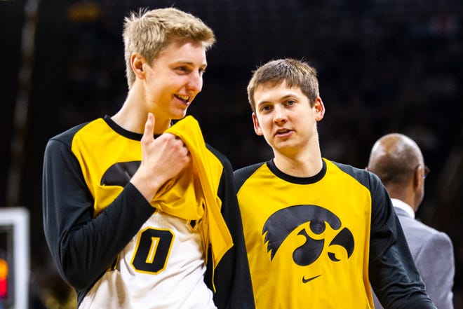 Iowa forward Michael Baer (0) talks with Iowa guard Austin Ash (right) during a NCAA Big Ten Conference men's basketball game on Sunday, Jan. 20, 2019, at Carver-Hawkeye Arena in Iowa City, Iowa.