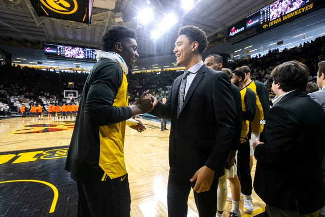 Iowa forward Tyler Cook (left) shakes hands with Cordell Pemsl before a NCAA Big Ten Conference men's basketball game on Sunday, Jan. 20, 2019, at Carver-Hawkeye Arena in Iowa City, Iowa.