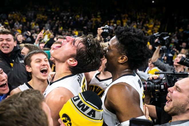 Iowa forward Luka Garza (55) celebrates with Iowa guard Austin Ash, left, and Tyler Cook, right, during a NCAA Big Ten Conference men's basketball game on Friday, Feb. 1, 2019, at Carver-Hawkeye Arena in Iowa City, Iowa. The Hawkeyes defeated Michigan's Wolverines, 74-59.