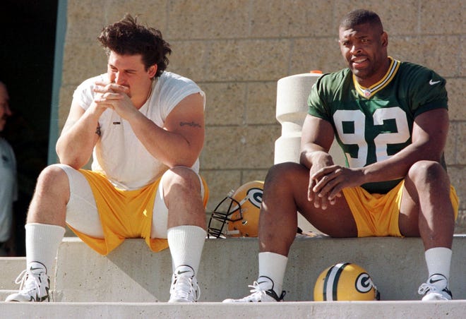 Green Bay offensive lineman Ross Verba, left, and defensive lineman Reggie White wait for practice before Super Bowl XXXII, where the defending champion Packers lost to the Denver Broncos.