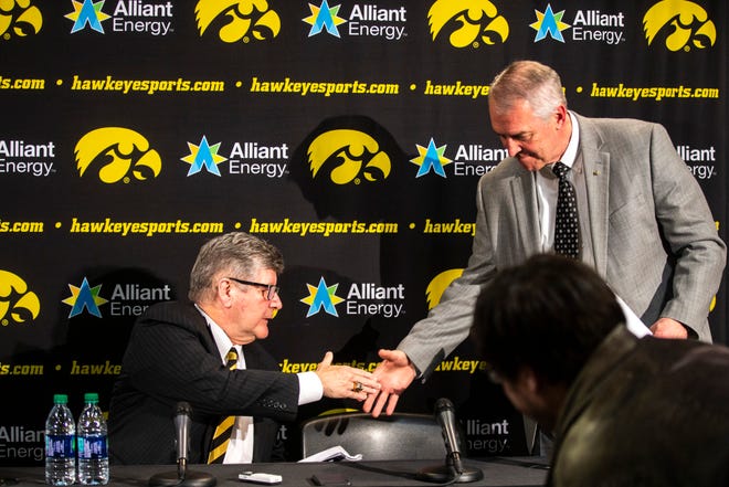Iowa play-by-play commentator Gary Dolphin, left, and Iowa athletic director Gary Barta shake hands during a press conference on Wednesday, Feb. 27, 2019, at Carver-Hawkeye Arena in Iowa City, Iowa.