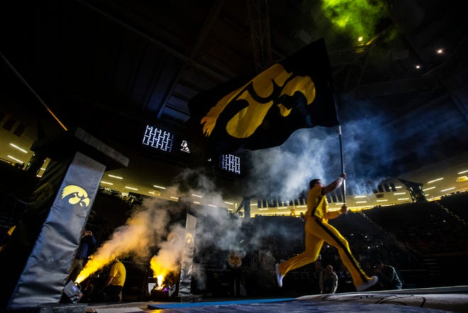 A member of the spirit squad carries out a Tigerhawk flag during a NCAA Cy-Hawk series women's gymnastics meet on Friday, March 1, 2019, at Carver-Hawkeye Arena in Iowa City, Iowa.