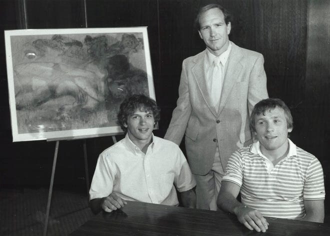 From 1984: Iowa wrestling coach Dan Gable, back, with Hawkeyes wrestlers Randy lewis, left, and Barry Davis, at Babe's Restaurant in Des Moines celebrating the release of artwork commemorating Gable's Olympic gold medal at the 1972 Olympic Games in Munich, West Germany.