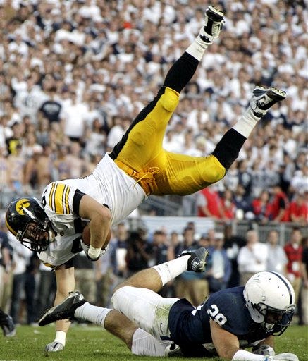 Iowa tight end Zach Derby, top left, is upended by Penn State safety Drew Astorino during the third quarter of an NCAA college football game in State College, Pa., Saturday, Oct. 8, 2011. Penn State won 13-3.