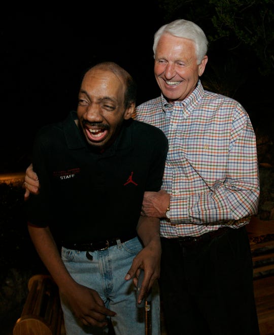 Former Arizona coach Lute Olson, right, shares a moment with his former player, Kenny Arnold, in Tucson, Arizona, in 2005. Olson and the rest of the team raised money to help pay for Arnold's medical expenses.