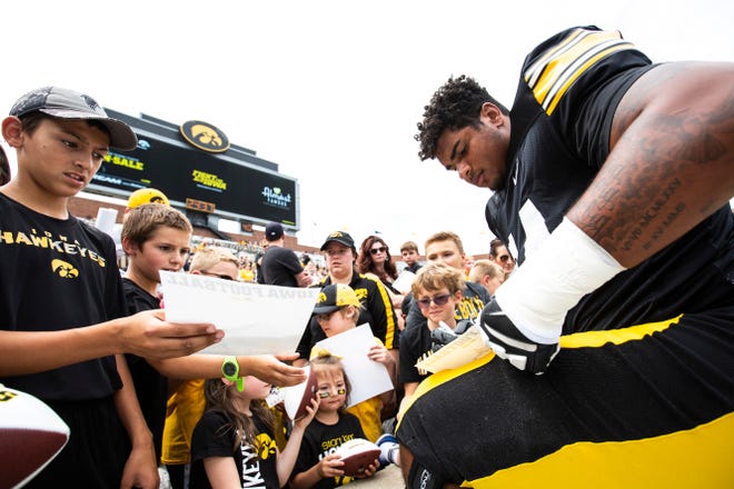 Iowa offensive lineman Tristan Wirfs (74) signs autographs for young fans during a Hawkeyes football Kids Day scrimmage, Saturday, Aug. 10, 2019, at Kinnick Stadium in Iowa City, Iowa.