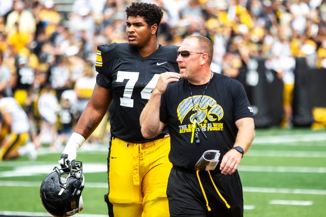 Iowa offensive line coach Tim Polasek (right, with outgoing tackle Tristan Wirfs) now has three offensive linemen committed to the Hawkeyes' 2021 class.