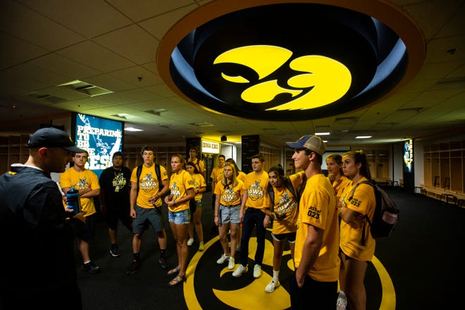Josh Berka, associate director of event management at the University of Iowa athletics department, talks while University of Iowa freshman students from the class of 2023 get a behind the scenes tour inside the Hawkeyes locker room, Friday, Aug. 23, 2019, at Kinnick Stadium in Iowa City, Iowa.