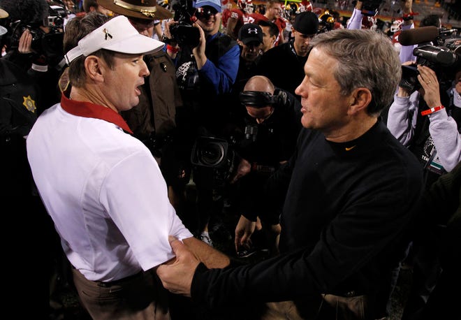 Oklahoma head coach Bob Stoops and Iowa head coach Kirk Ferentz meet on the field after the Insight Bowl in December 2011. The two will be in the same building again Saturday, as Stoops is Iowa's honorary captain for Week 1.