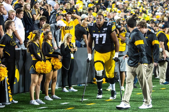 Iowa offensive lineman Alaric Jackson (77) walks off the field on crutches in the second quarter during a NCAA non conference football game, Saturday, Aug. 31, 2019, at Kinnick Stadium in Iowa City, Iowa.