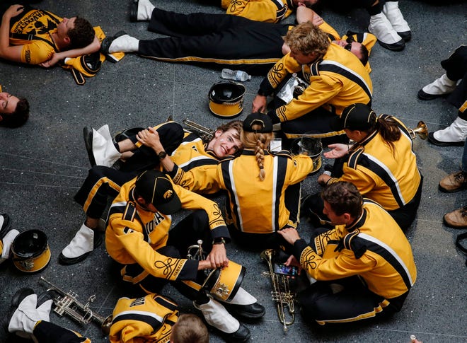 Members of the Iowa Marching Band relax during a weather delay against Iowa State on Saturday, Sept. 14, 2019, at Jack Trice Stadium in Ames.