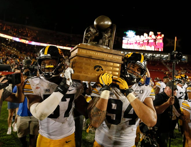 From 2019: Iowa defensive linemen Chauncey Golston, left, and A.J. Epenesa carry the Cy-Hawk trophy off the field after their 18-17 win over Iowa State on Sept. 14, 2019, at Jack Trice Stadium in Ames. It was the Hawkeyes ' fifth straight win in the rivalry.