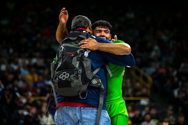 Sonny Santiago, of California, (green) embraces his coach after a victory during a match at 152 pounds during Flowrestling's Who's Number One event, Saturday, Oct., 5, 2019, at Carver-Hawkeye Arena in Iowa City, Iowa.