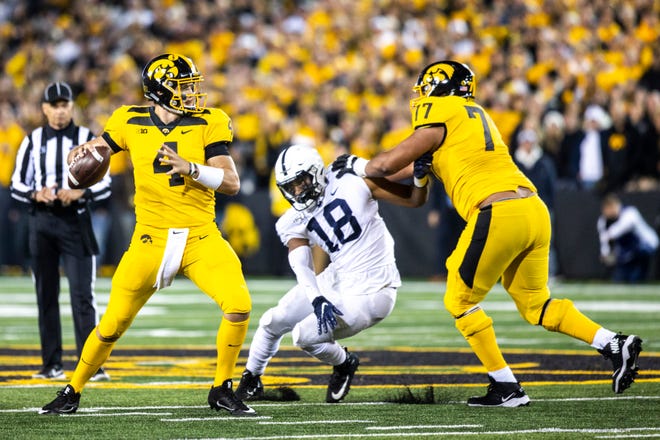 Iowa quarterback Nate Stanley (4) looks to get a pass out as Iowa offensive lineman Alaric Jackson (77) blocks against Penn State defensive end Shaka Toney (18) during a NCAA Big Ten Conference football game between the Iowa Hawkeyes and Penn State, Saturday, Oct., 12, 2019, at Kinnick Stadium in Iowa City, Iowa.