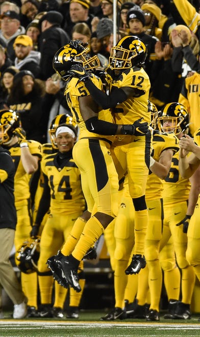 Iowa Hawkeyes defensive end Chauncey Golston (57) and wide receiver Brandon Smith (12) react after a sack during the first quarter against the Penn State Nittany Lions at Kinnick Stadium.