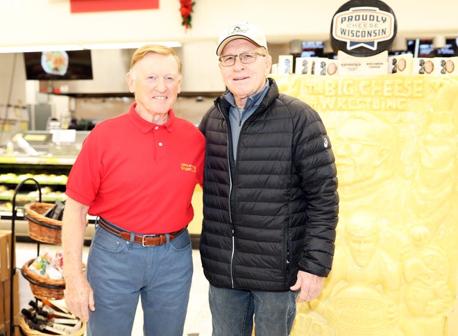 Former ISU wrestler John Accola (North High Class of 1963) stops for a picture with Dan Gable during a meet and greet with Iowa wrestling legend Dan Gable and a 3,000-pound wheel of aged white cheddar cheese sculpture of him on Sunday, Nov. 17, 2019, at the Hy-Vee, 410 N. Ankeny Blvd., in Ankeny.