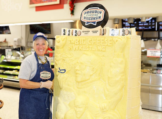 Sarah "Cheese Lady" Kaufmann stands next to her creation during a meet and greet with Iowa wrestling legend Dan Gable and a 3,000-pound wheel of aged white cheddar cheese sculpture of him on Sunday, Nov. 17, 2019, at the Hy-Vee, 410 N. Ankeny Blvd., in Ankeny.
