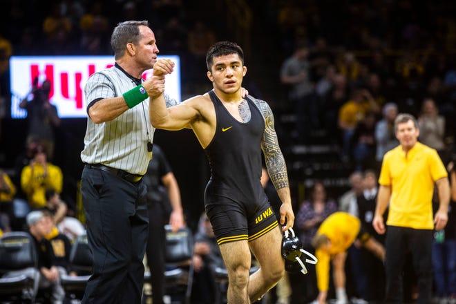 Iowa's Pat Lugo has his hand raised after defeating Wisconsin's Cole Martin (not pictured) during a NCAA Big Ten Conference wrestling dual, Sunday, Dec. 1, 2019, at Carver-Hawkeye Arena in Iowa City, Iowa. Lugo won, 5-3.