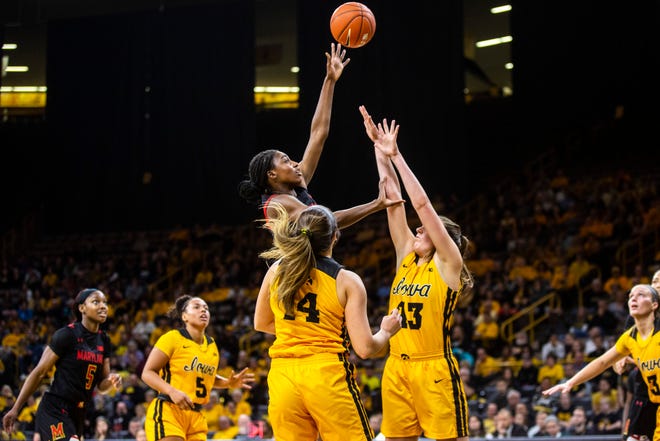 Maryland guard Diamond Miller makes a basket as Iowa's McKenna Warnock (14) and Amanda Ollinger (43) defend during a NCAA college Big Ten Conference women's basketball game, Thursday, Jan. 9, 2020, at Carver-Hawkeye Arena in Iowa City, Iowa.