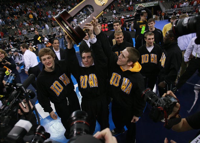 Iowa's Jay Borschel, Brent Metcalf and Matt McDonough celebrate with the team championship trophy at the 2010 NCAA Wrestling Championships at the Qwest Center in Omaha.